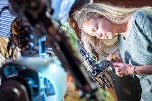 Engineer fixing robotic arm with screwdriver at workshop